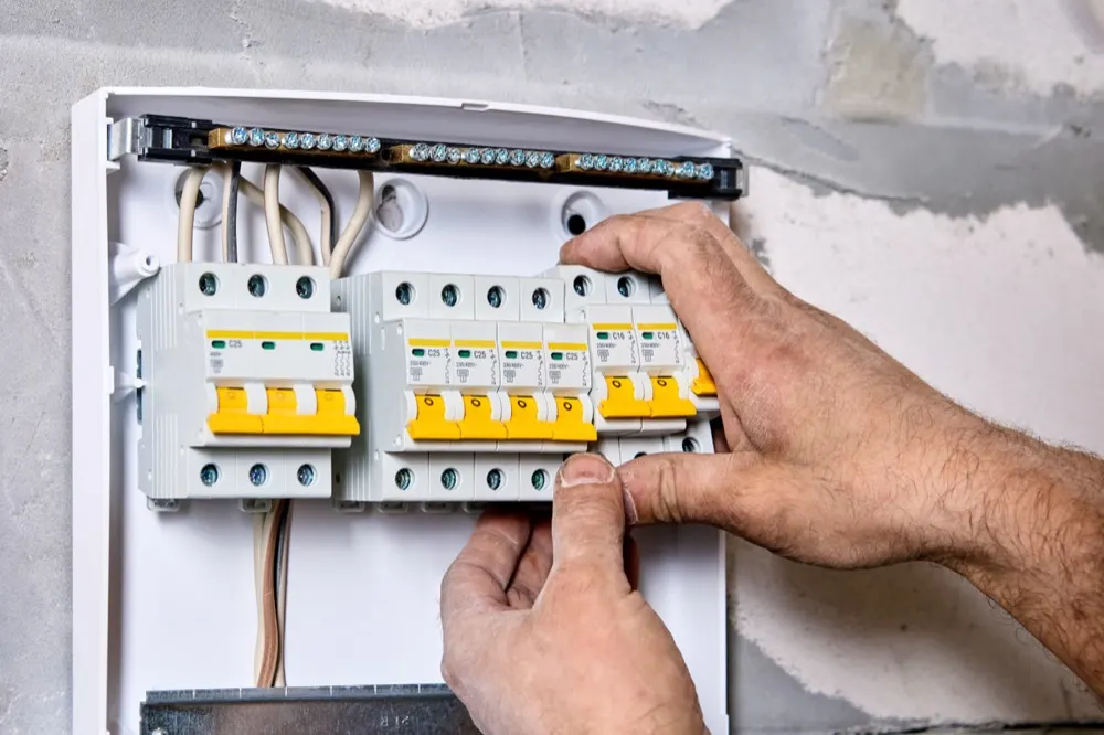 An electrician fitting circuit breakers into a consumer unit.